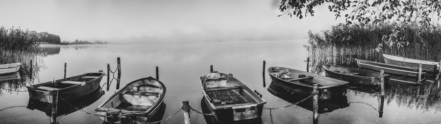 Panoramic view of boats moored in lake against sky