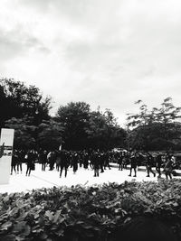 Group of people in cemetery against sky