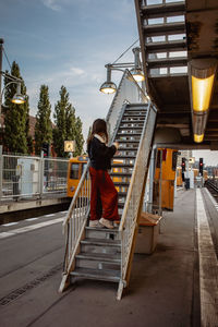 Full length of woman on steps at railroad station