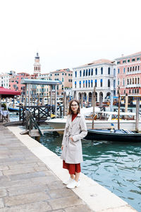 Young tourist in dress and coat on the streets of venice