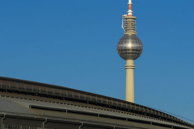 Low angle view of fernsehturm tv tower against blue sky