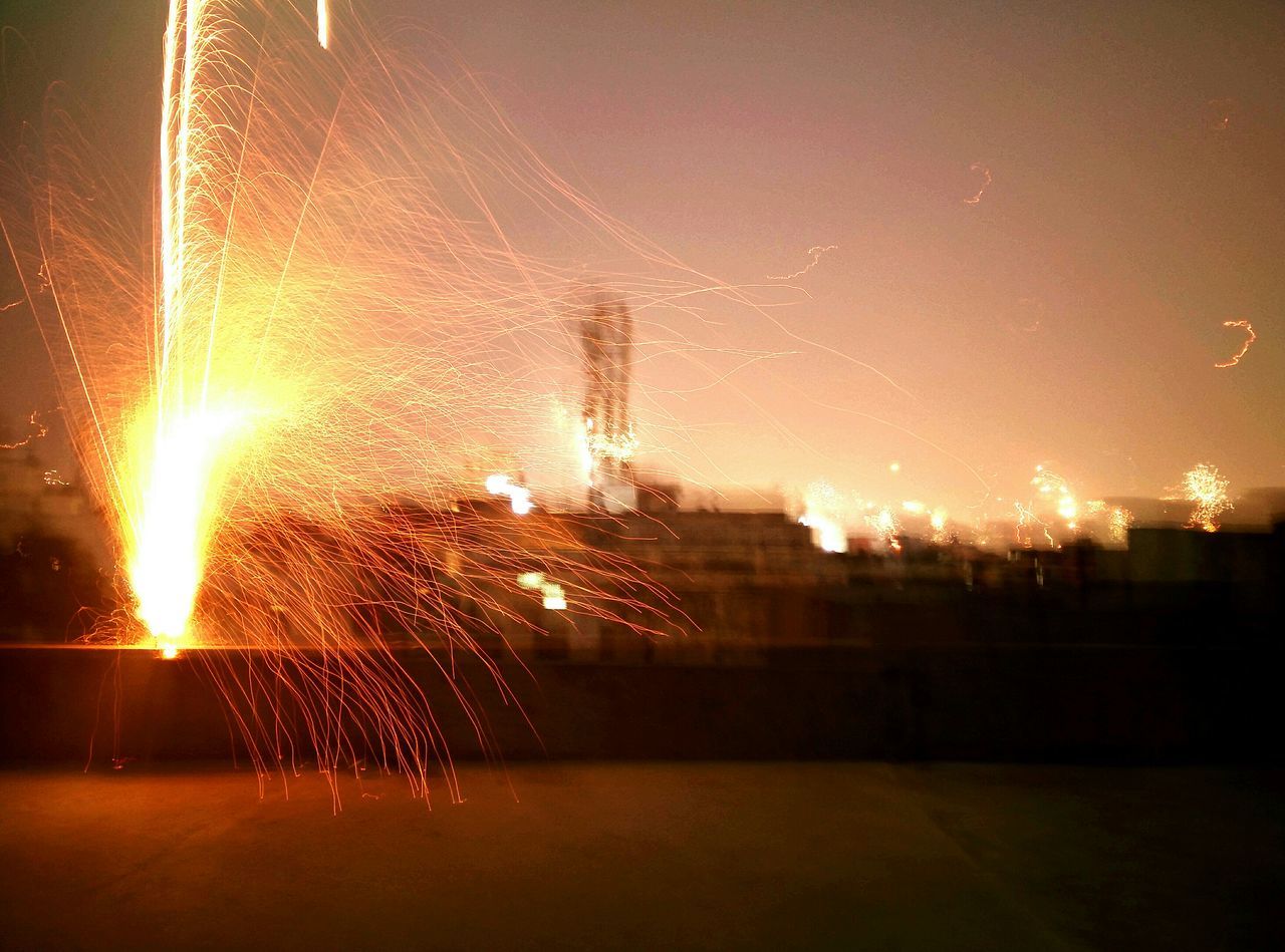 illuminated, night, glowing, long exposure, motion, electricity, lighting equipment, light - natural phenomenon, sparks, outdoors, exploding, no people, light, sky, firework display, blurred motion, water, firework - man made object, focus on foreground, silhouette