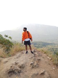 Rear view of man on mountain against sky