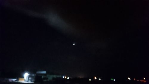 Low angle view of illuminated city against sky at night