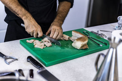 Midsection of man holding fish on table