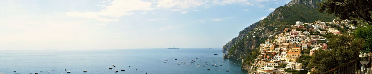 Panoramic view of beach by city against sky