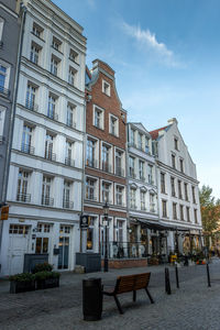 Building by street in city against sky