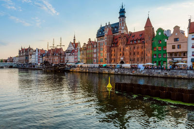 River amidst buildings in city against sky