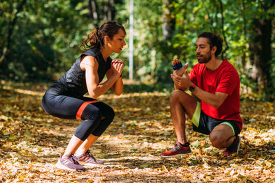 Young couple exercising with elastic resistance band outdoors in the park