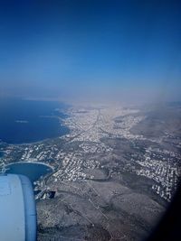 Aerial view of snowcapped landscape against blue sky