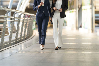 Low section of people walking on zebra crossing