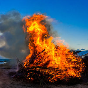 Bonfire on beach against sky