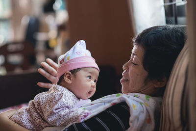 Grandmother with cute baby at home