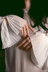 Midsection of woman holding umbrella standing outdoors