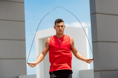 Young man exercising against building outdoors