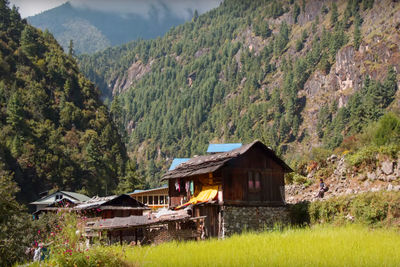 Houses by mountains against sky