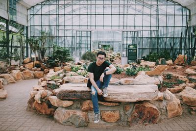 Portrait of man sitting in greenhouse