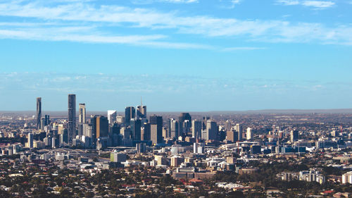 Aerial view of buildings in city against sky