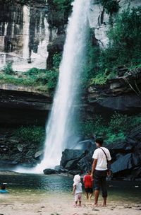 Rear view of people at waterfall