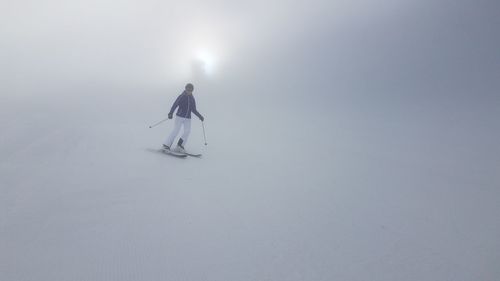 Man skiing in snow against sky