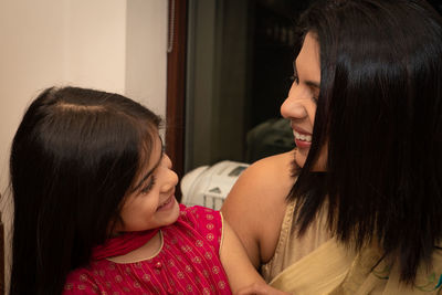 Smiling mother and daughter indoors