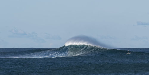 Wave splashing in sea against sky