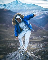 Full length of man standing on rock against mountains