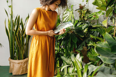 Midsection of woman holding plant