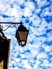 Low angle view of street light against cloudy sky