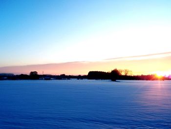Scenic view of lake against clear sky during sunset
