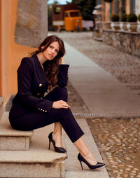 Portrait of young woman standing against wall