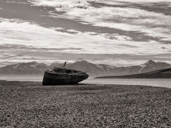 Whaler boat on sea shore against sky, svalbard coast