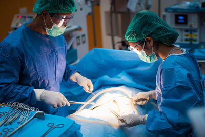 Surgeons operating patient in hospital