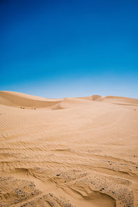 Scenic view of desert against blue sky