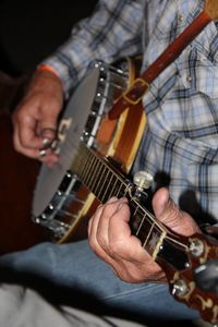 Close-up of man playing guitar