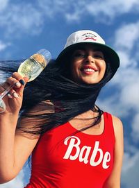 Portrait of smiling young woman holding camera