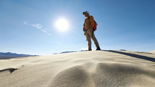 Man standing on sand against sky