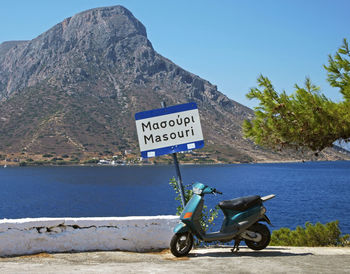 Bicycle on road by sea against clear sky