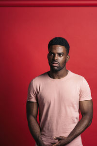 Portrait of young man against red background