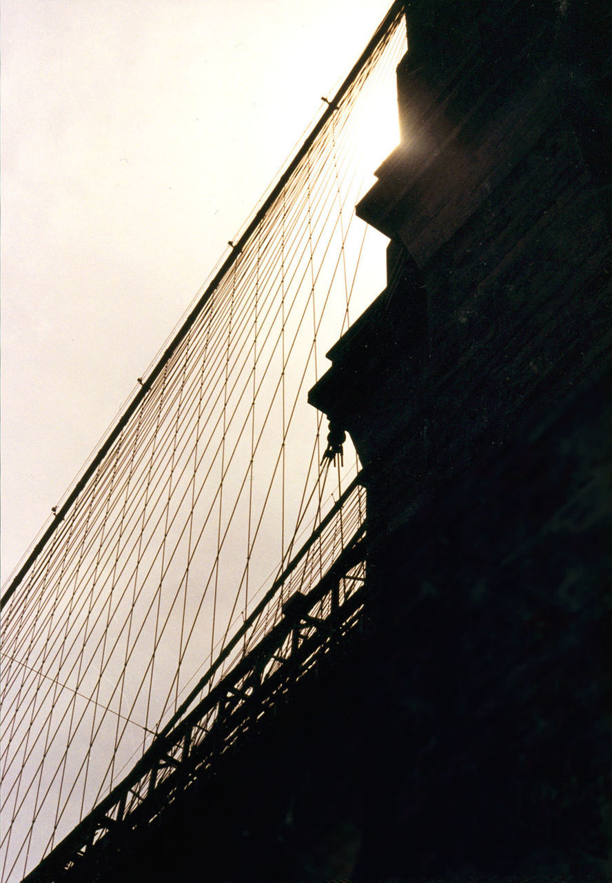 architecture, built structure, low angle view, clear sky, bridge - man made structure, building exterior, connection, sky, building story, outdoors, day, tall - high, skyscraper, modern, engineering, suspension bridge, tall, no people, surface level, office building