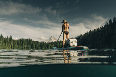 A young woman enjoys a standup paddle board on lost lake in oregon.