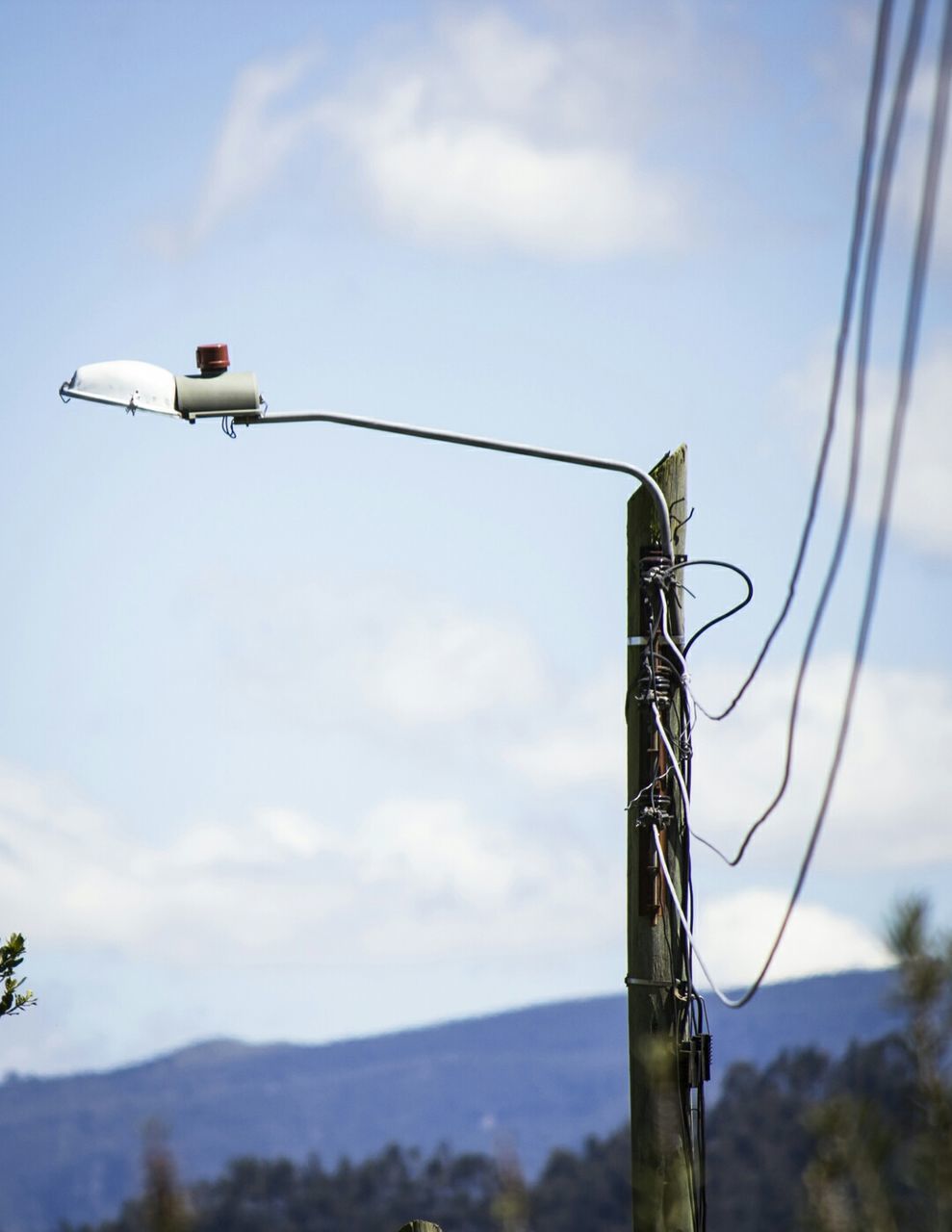 sky, low angle view, cloud - sky, cloud, cloudy, pole, technology, lighting equipment, day, metal, guidance, outdoors, no people, street light, electricity, focus on foreground, fuel and power generation, safety, communication, blue