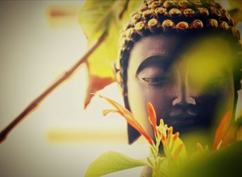 Close-up buddha statue amidst plant