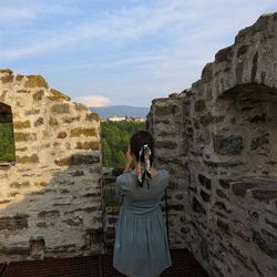 Rear view of woman photographing at camera