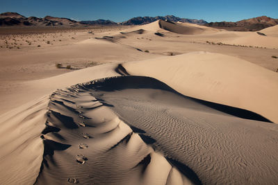 Sand dune in desert against sky