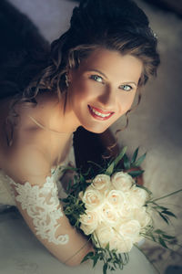 High angle portrait of happy beautiful bride with hand on chin at home