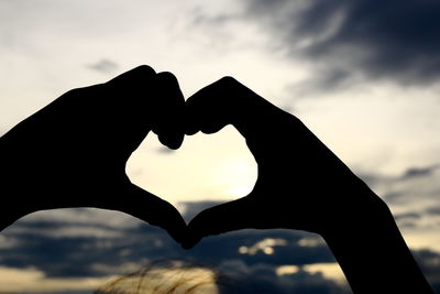 Close-up of silhouette man heart shape against sky during sunset