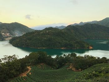 Scenic view of lake by mountains against sky