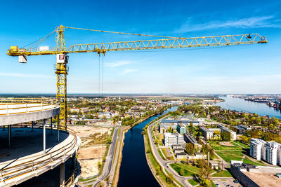 Cranes at construction site against sky in city