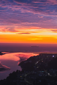 Scenic view of sea against dramatic sky during sunset